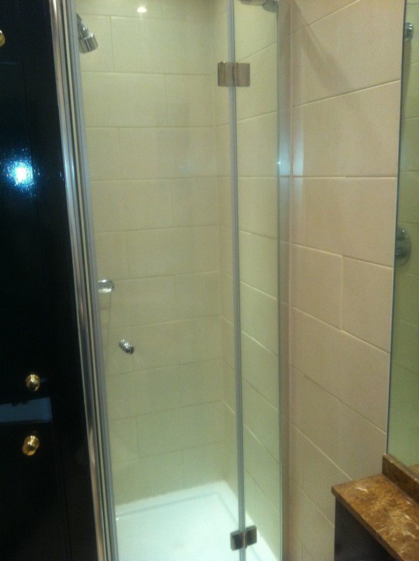 Frameless glass shower enclosure with chrome fittings in East Molesey